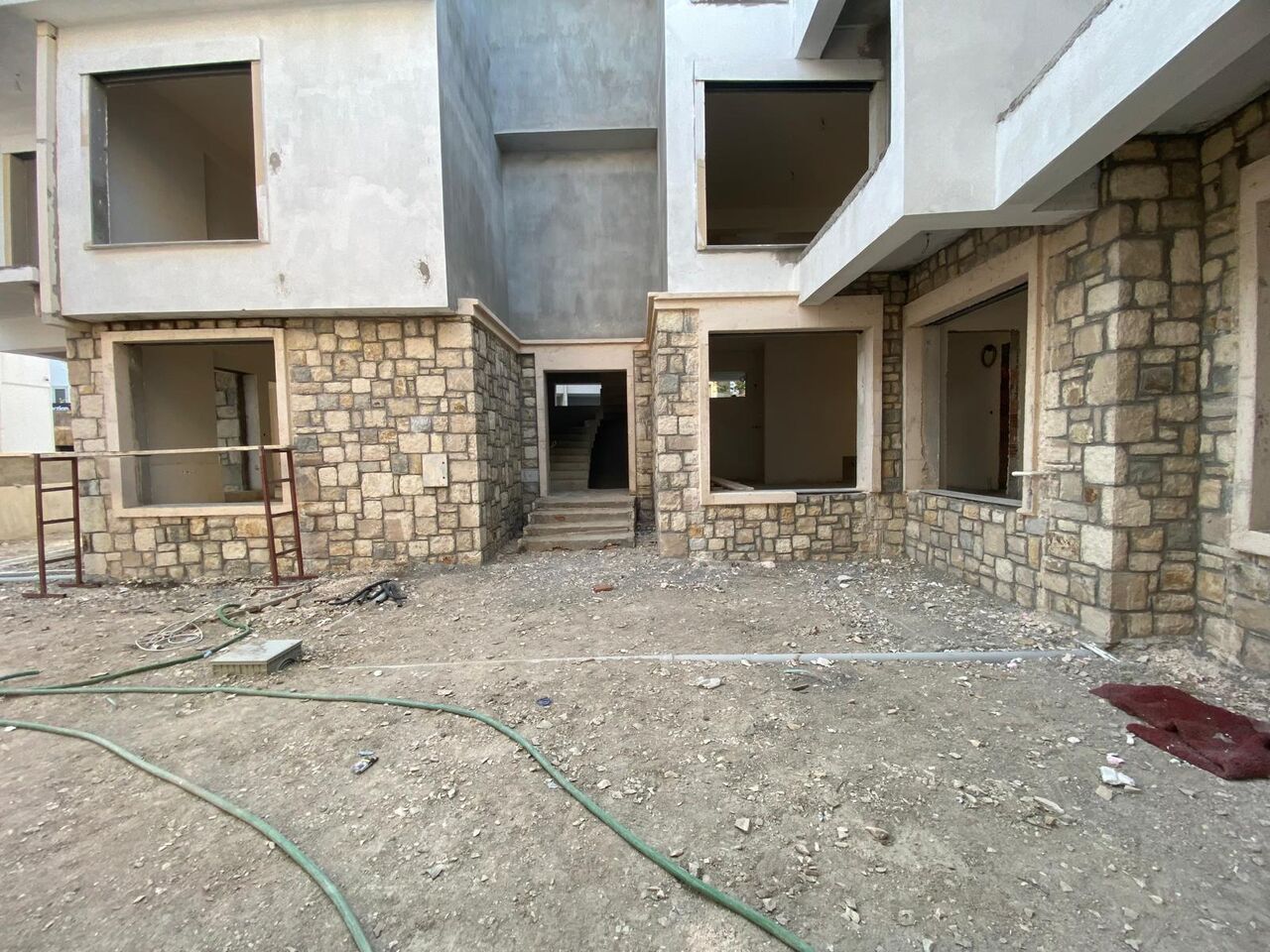 Urla'da kaba yapı aşamasındaki villa girişi ve taş kaplamalı kolonlar