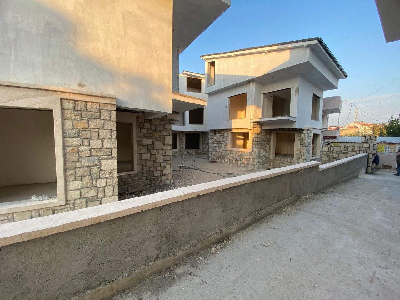 Urla'da taş kaplamalı iki katlı villa inşaatı ve beton bahçe duvarı